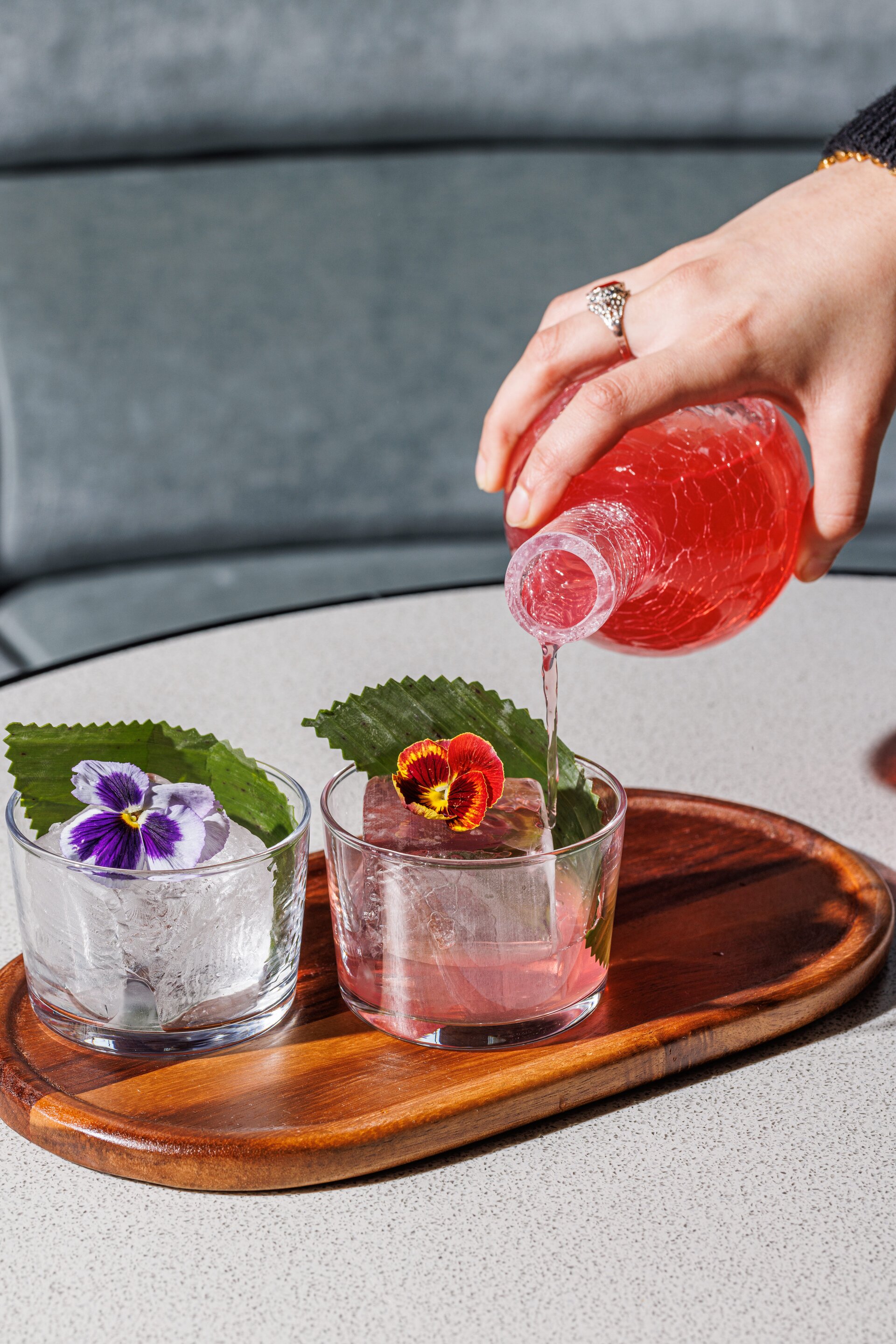 Hand pouring cocktail into glasses